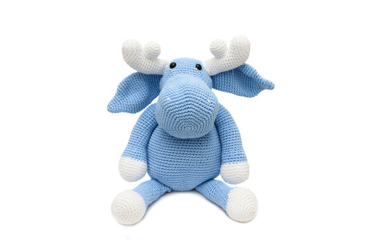Alce azul de pel&uacute;cia, feito na t&eacute;cnica de croch&ecirc; amigurumi visto de frente sobre um fundo branco