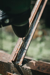 Man drilling hole in metal construction