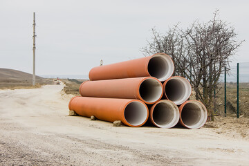 Large diameter water pipes are located at the edge of the road.