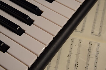 Electric piano, keyboard piano, pianino klawisze instrumentu, pod spodem nuty © Anna