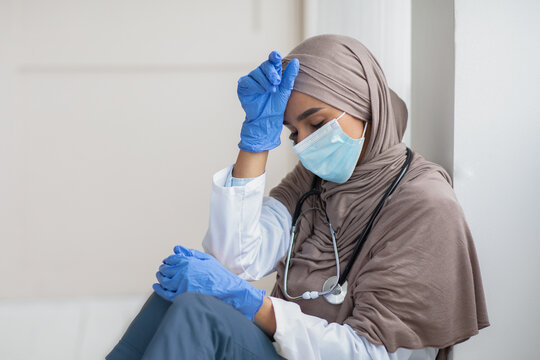 Upset woman in hijab doctor having difficult day at clinic