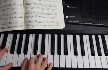 Electric piano, keyboard piano, pianino klawisze instrumentu nuty do gry i dziecięce dłonie