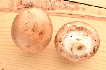Two organic fresh, cream champignons, close up, on a wooden table.