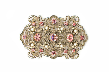 Gold brooch with pink stones on a white background. Large brooch