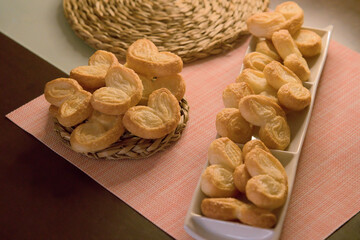Palms of puff pastry on white rectangular plate and wicker plate