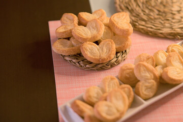 Palms of puff pastry on white rectangular plate and wicker plate