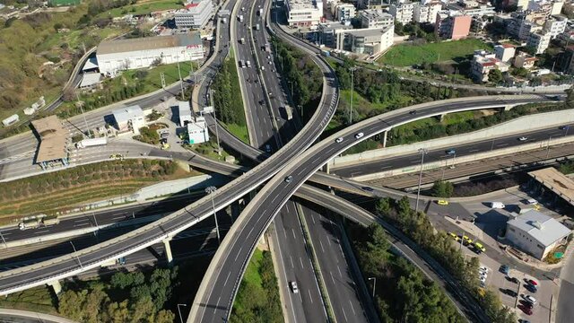 Aerial drone top down time-lapse video of motorway multilevel junction crossing through national road during rush hour, Attica, Athens, Greece.