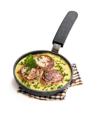 Tenderloin medallions with mustard sauce in frying pan isolated on white
