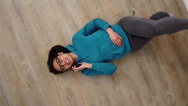 Young woman lies on the floor and makes phone calls - videoclip
