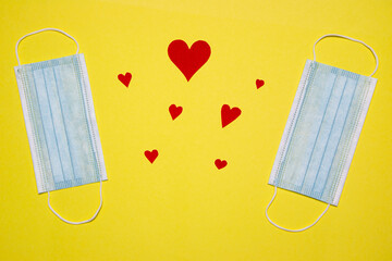 Disposal protective masks and a red hearts on a yellow background. Valentines Day theme