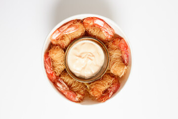 Aerial view of a cube of fried prawns wrapped in Kataifi pasta and served with dragon sauce.
