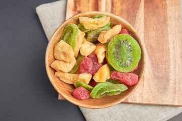 Assorted dehydrated fruit in wooden cup.