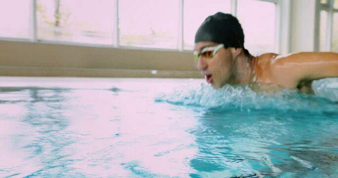 Disabled amputee athlete butterfly swimming in indoor pool