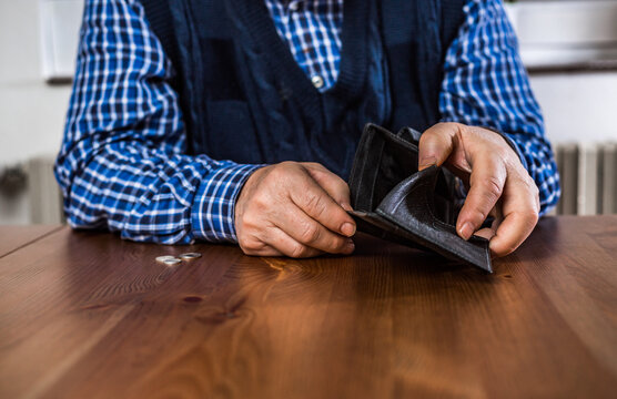 An old senior man showing an empty wallet without money during covid-19, coronavirus pandemic, economic crisis