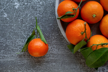 Fototapeta na wymiar Citrus fruits mandarin layout. Fresh tangerines on grey concrete background.