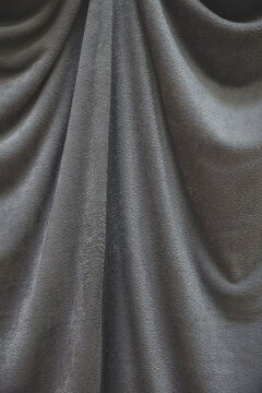 Close up of draped grey velvet fabric, focus on folds and creases