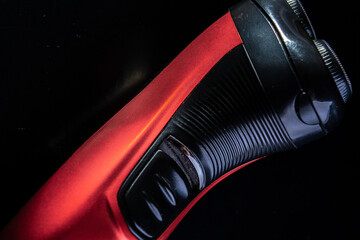 Black and red electric razor on a black background