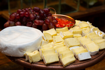 Brie cheese with guava jam on the wooden board.