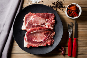 raw beef steak, on a black plate
