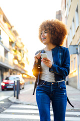 happy african american young woman with cellphone in city