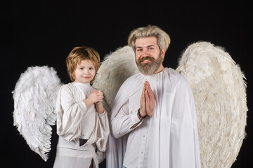 Valentines angels. Father with son in angel costumes. Valentine day. Cute angel. Cupid boy pray...