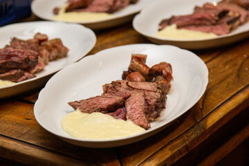 Barbecue with anchovy meat and sausage served with aligot.