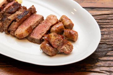 Barbecue with anchovy meat and sausage served with aligot.