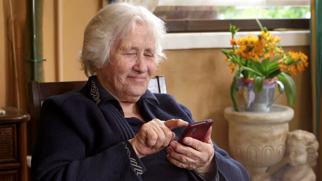 smiling toothless elderly woman typing on the mobile phone