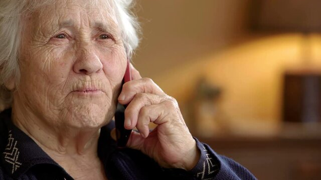 sweet toothless elderly lady talking on mobile