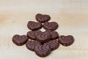 Close up view of chocolate cookies in heart shape on wooden background. Valentines day concept.  