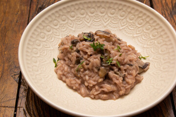 Mushroom risotto, on the wooden table.