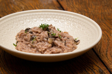 Mushroom risotto, on the wooden table.