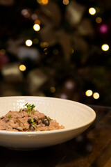 Mushroom risotto on the wooden table on christmas background.