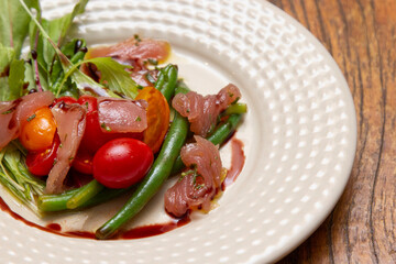 Nicoise salad - salad made with arugula, chopped tomatoes and anchovies.