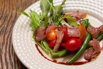 Nicoise salad - salad made with arugula, chopped tomatoes and anchovies.