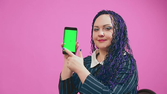 Stylish brunette with blue afro braids leafing through the smartphone screen green screen. Medium plan