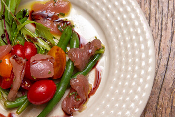 Nicoise salad - salad made with arugula, chopped tomatoes and anchovies.