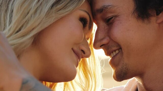 Adorable couple embraced face to face lovingly caressing each other smiling - Close up