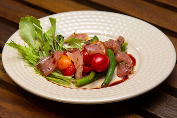 Nicoise salad - salad made with arugula, chopped tomatoes and anchovies.