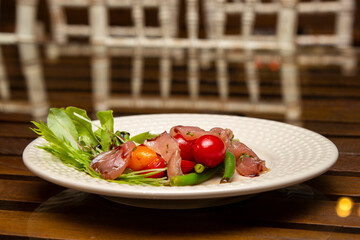 Nicoise salad - salad made with arugula, chopped tomatoes and anchovies.