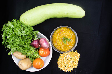 Indian Ghiya Bottle Gourd Calabash Long Melon New Guinea bean Chana Daal Yellow Lentils Vegetable Curry Main Course With Recipes On Black Background