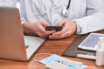 Physician using a phone to communicate with a patient