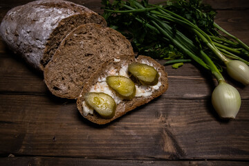 sandwich with lard and pickled cucumber on wooden table
