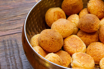 Brazilian cheese bread in a pan on wooden table.