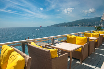 a cafe on the Black Sea coast in a recreation area of a Russian resort with wicker chairs and tables