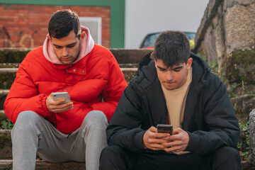 young people with mobile phone sitting on the stairs