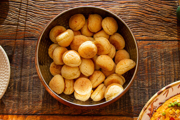 Brazilian cheese bread in a pan on wooden table.