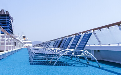 Vue du pont supérieur et des transats d'un navire de croisière en escale au terminal du port de Marseille.