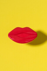 Creative female red lips on a yellow background. Minimal beauty concept.