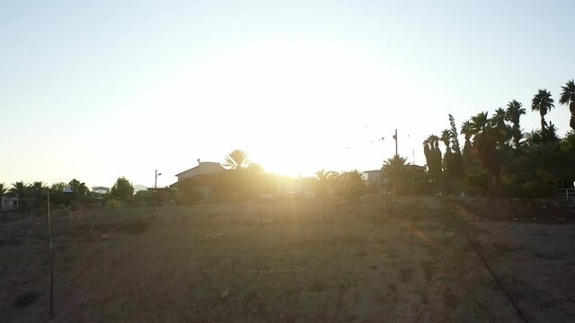Small village in the desert at sunset, aerial view
drone view Palm trees Mountains and red rofftops,vered yericho, Israel

